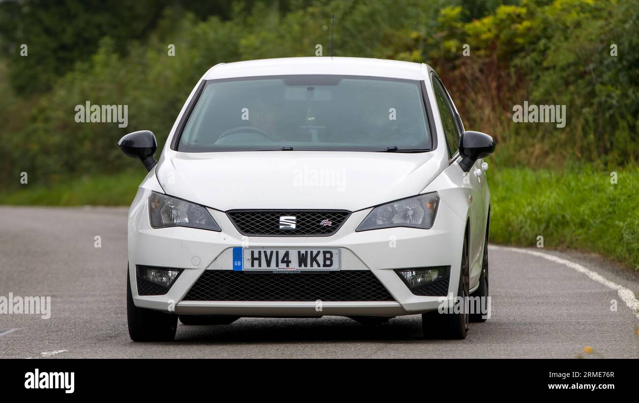 Whittlebury, Northants, Regno Unito - 26 agosto 2023: 2014 auto Seat Ibiza bianca che viaggia su una strada di campagna inglese Foto Stock