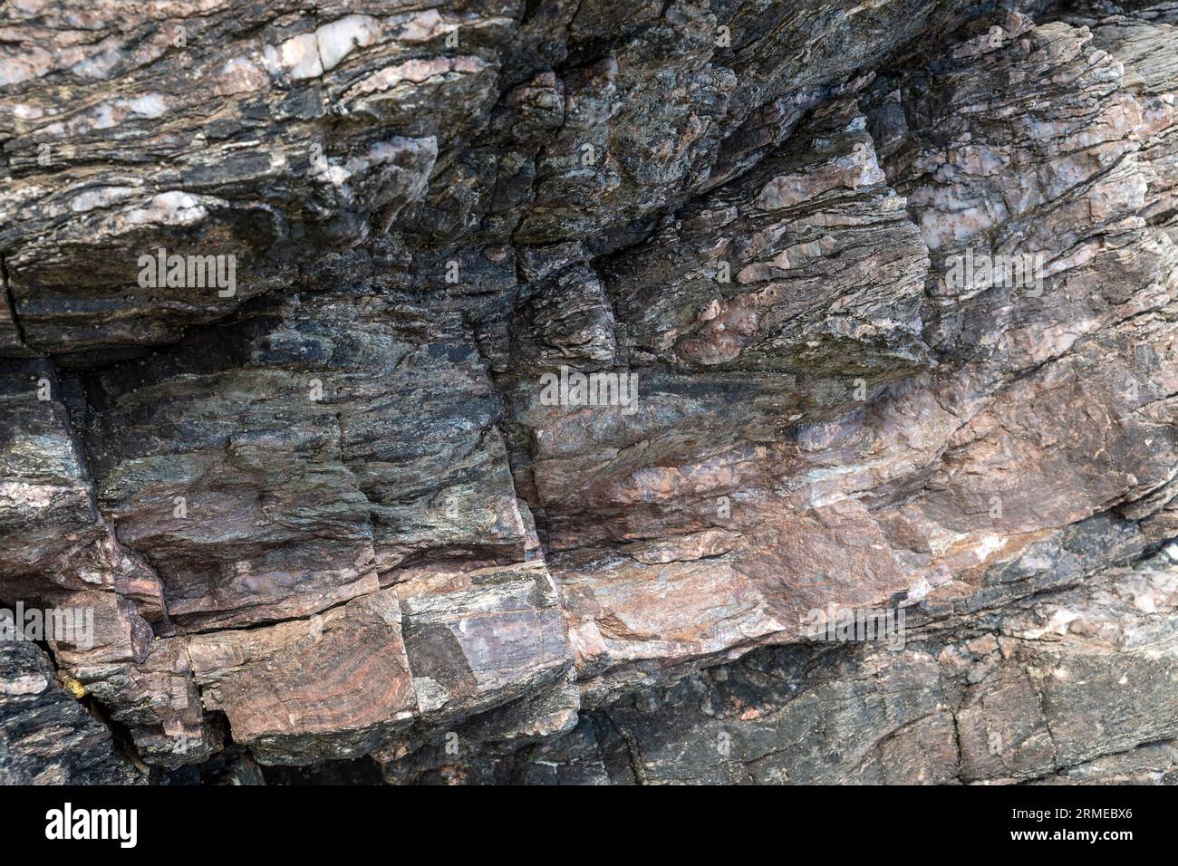 Bande di rocce laterite rosse (ferro dalla vegetazione) in colate laviche basaltiche, Murlough Bay, Irlanda del Nord, Regno Unito Foto Stock