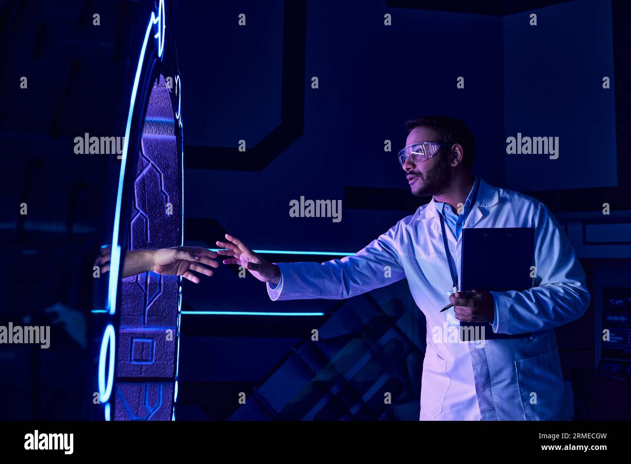 concetto futuristico, scienziato indiano toccante mano che appare da dispositivo sperimentale Foto Stock