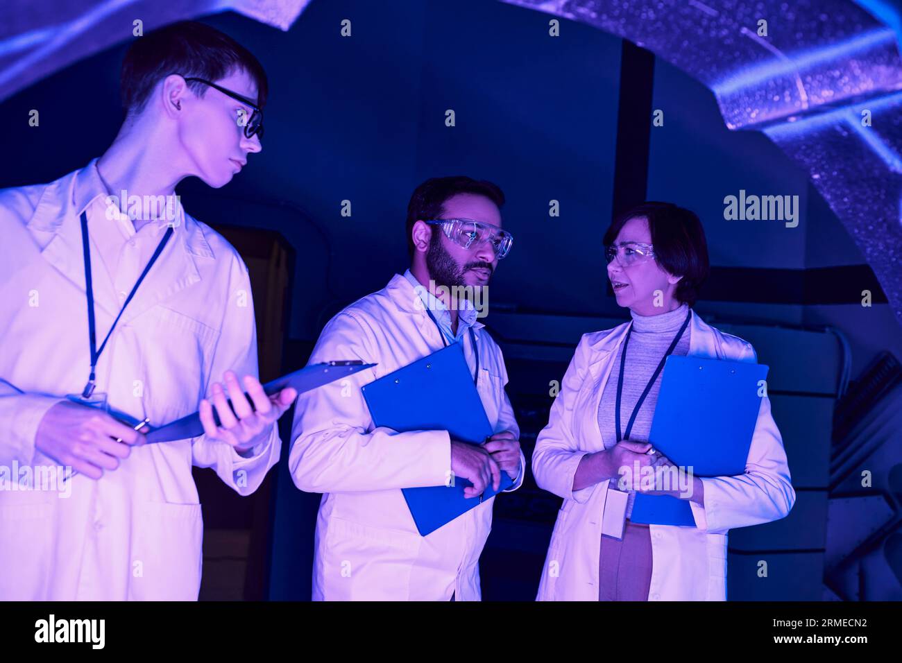 Collaborazione futuristica: Gli scienziati di varie epoche convergono nel Neon-Lit Science Center Foto Stock