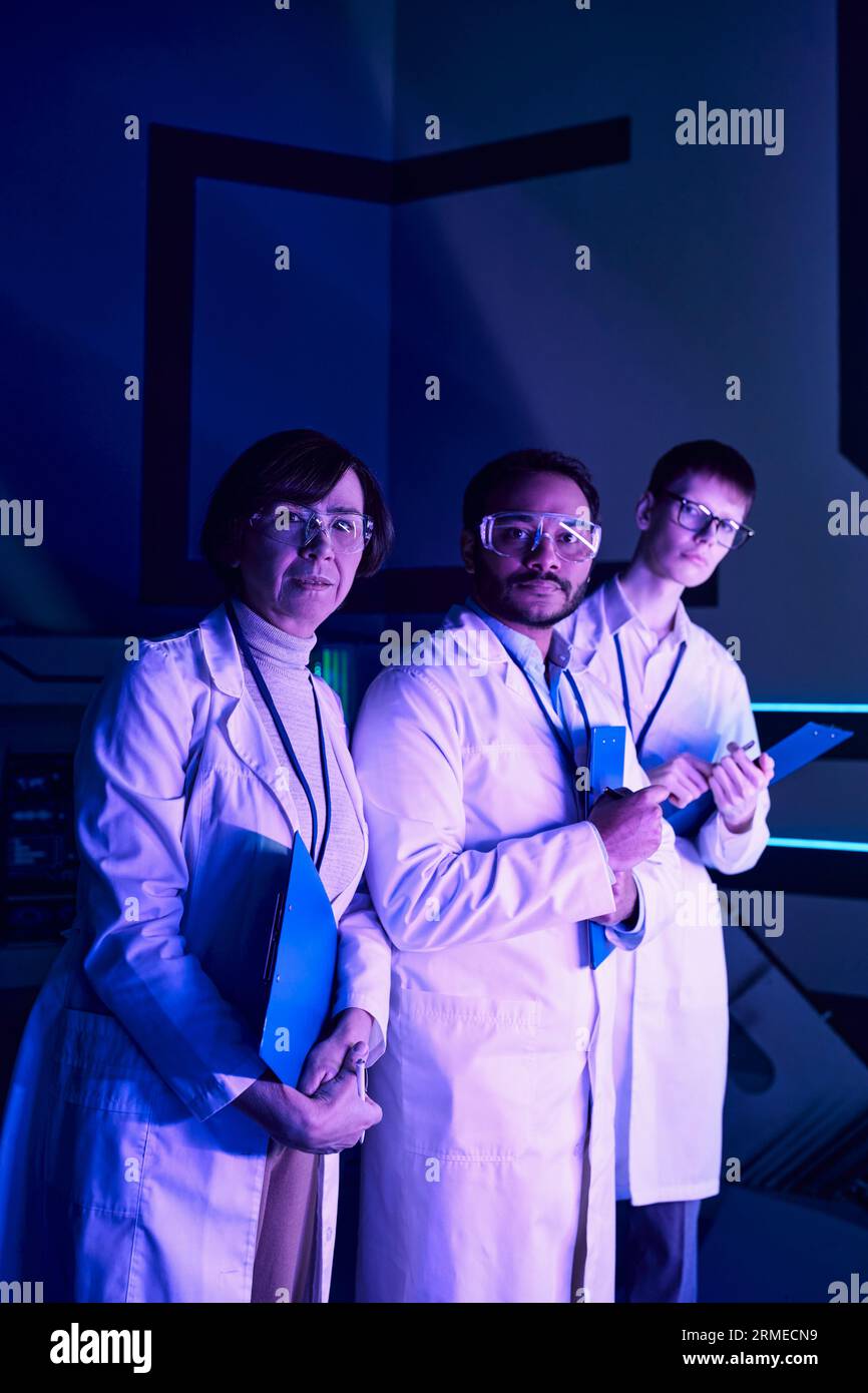 Obiettivo futuristico: Tre scienziati si impegnano in Headshot Stance, osservando il futuro nel Science Center. Foto Stock