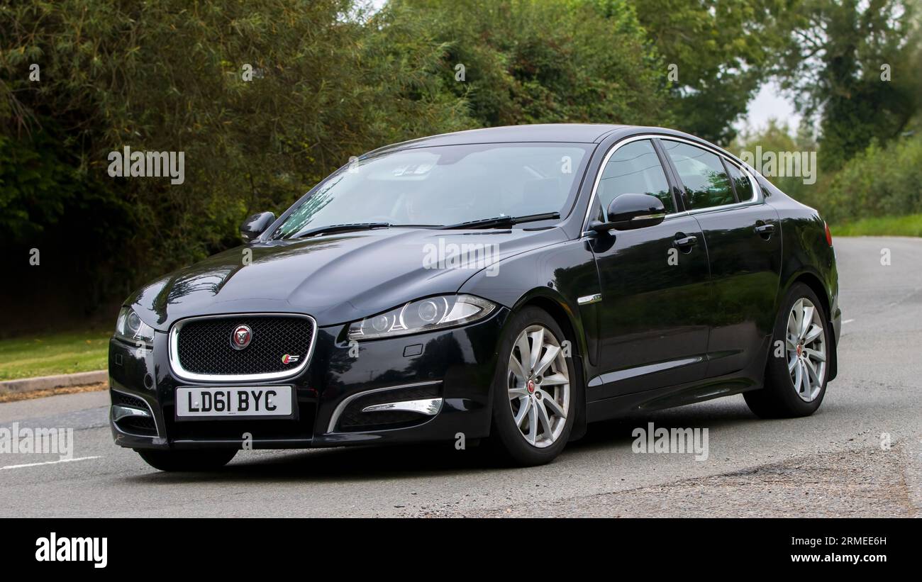 Whittlebury, Northants, Regno Unito - 26 agosto 2023: 2011 auto Jaguar XF nera che viaggia su una strada di campagna inglese Foto Stock