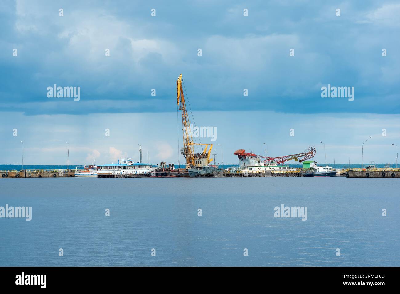 molo cargo con gru e navi tecniche in un giorno di pioggia Foto Stock