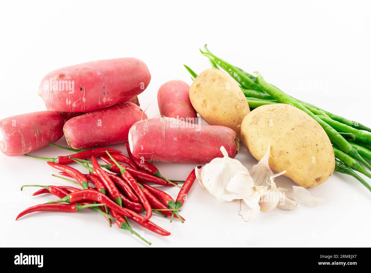 Scalpelli, peperoncino, ravanelli, patate e aglio su fondo bianco. Foto Stock