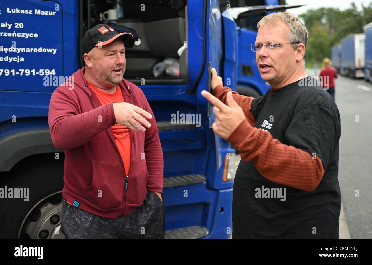 28 agosto 2023, Assia, Gräfenhausen: Il sindacalista olandese Edwin Atema (r), nominato dai camionisti dell'Europa orientale per guidare i negoziati, parla con Roman Koval di Leopoli (Ucraina). Per quasi sei settimane, i conducenti di un'azienda di trasporti polacca dell'Uzbekistan, della Georgia e di altri paesi dell'Europa orientale e dell'Asia centrale hanno scioperato nell'area di servizio dell'Assia meridionale. Gli uomini chiedono salari eccezionali. (Al dpa "parlamentare europeo per i conducenti in sciopero: Sono necessari più controlli") foto: Arne Dedert/dpa Foto Stock