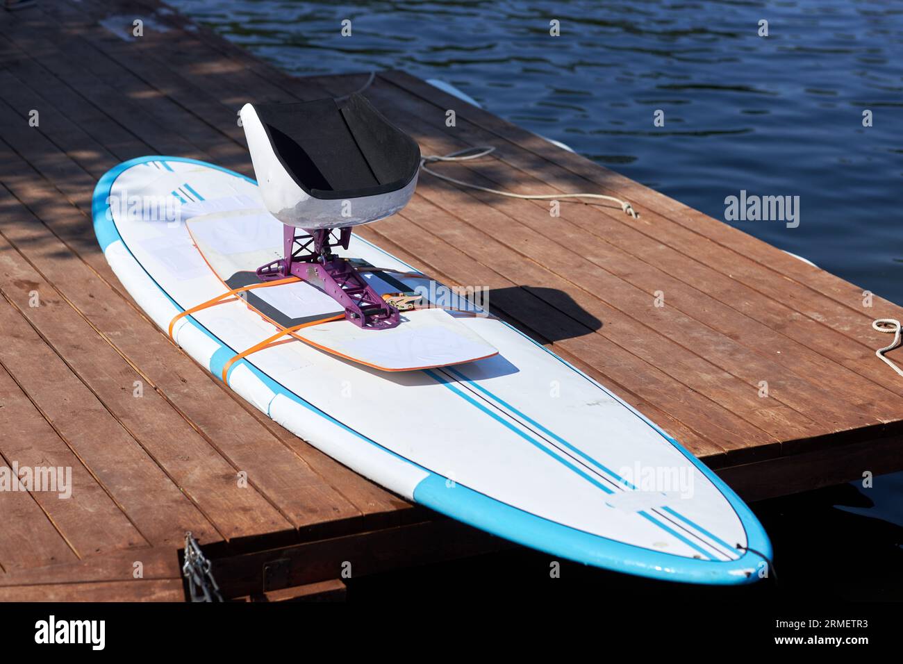 Primo piano della tavola da wakeboard con attrezzatura adattiva sul molo di legno all'aperto, spazio fotocopie Foto Stock