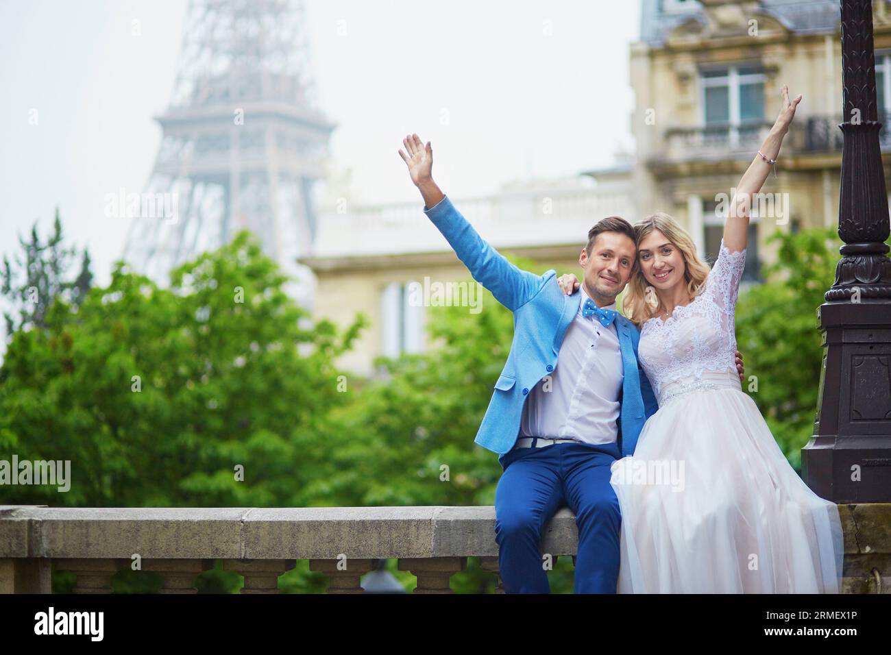 Solo una coppia sposata vicino alla Torre Eiffel il giorno del loro matrimonio. Sposo e sposo a Parigi, in Francia Foto Stock