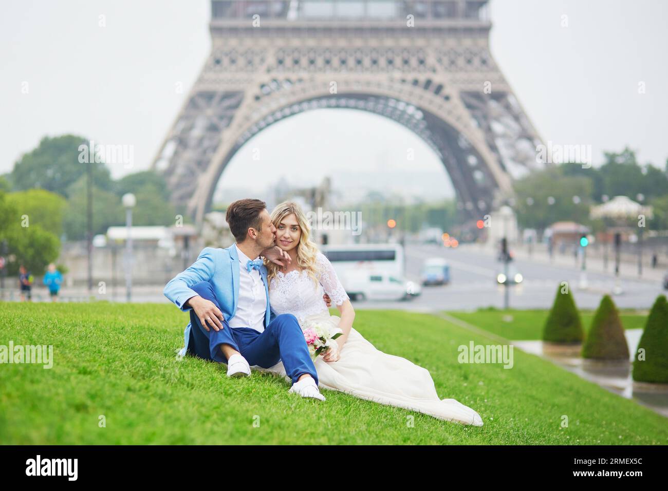 Solo una coppia sposata vicino alla Torre Eiffel il giorno del loro matrimonio. Sposo e sposo a Parigi, in Francia Foto Stock