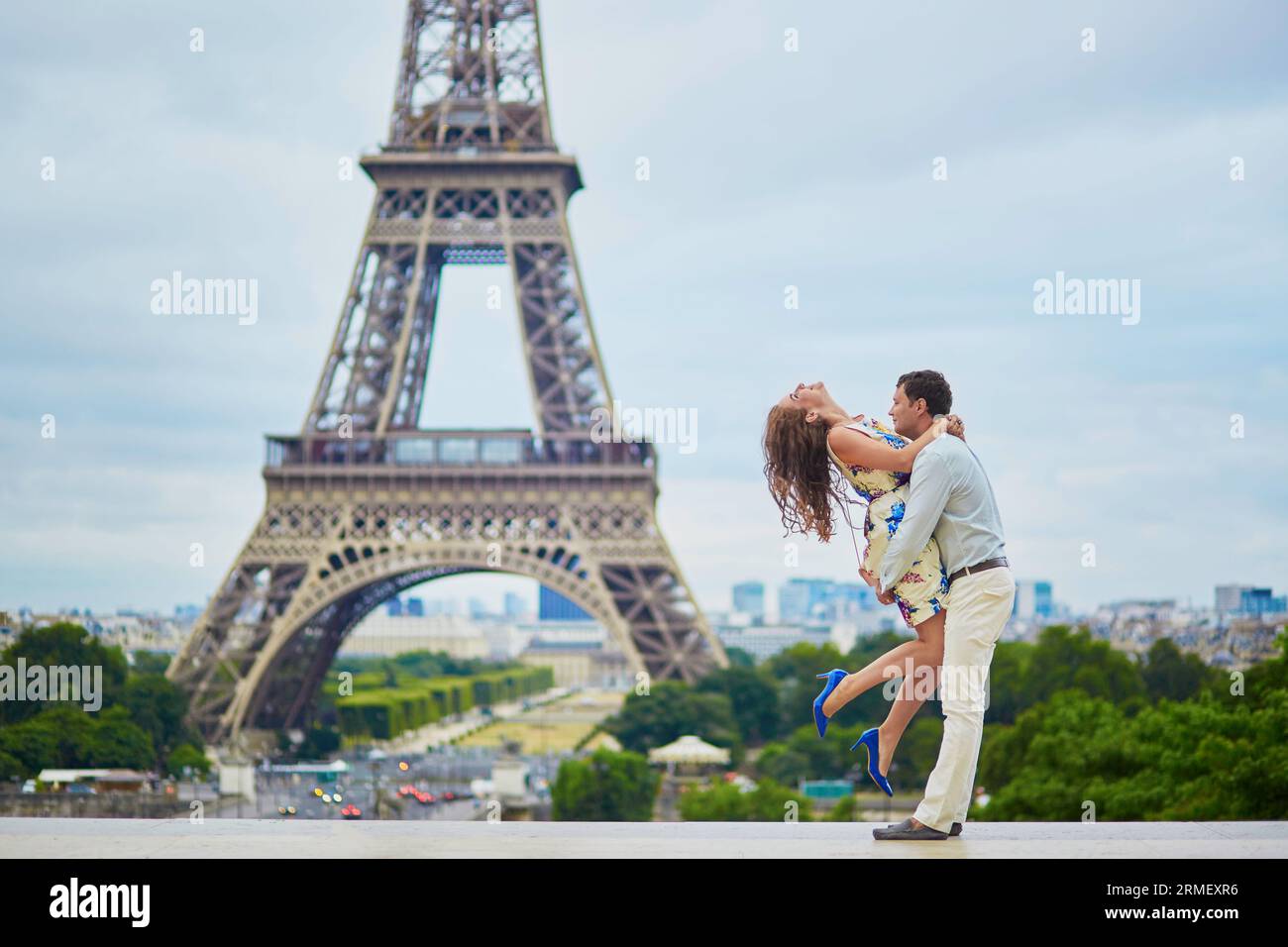 Coppia amorevole che ha un appuntamento vicino alla Torre Eiffel. Romantico abbraccio da salto. Turisti in vacanza o durante la loro luna di miele a Parigi, in Francia Foto Stock