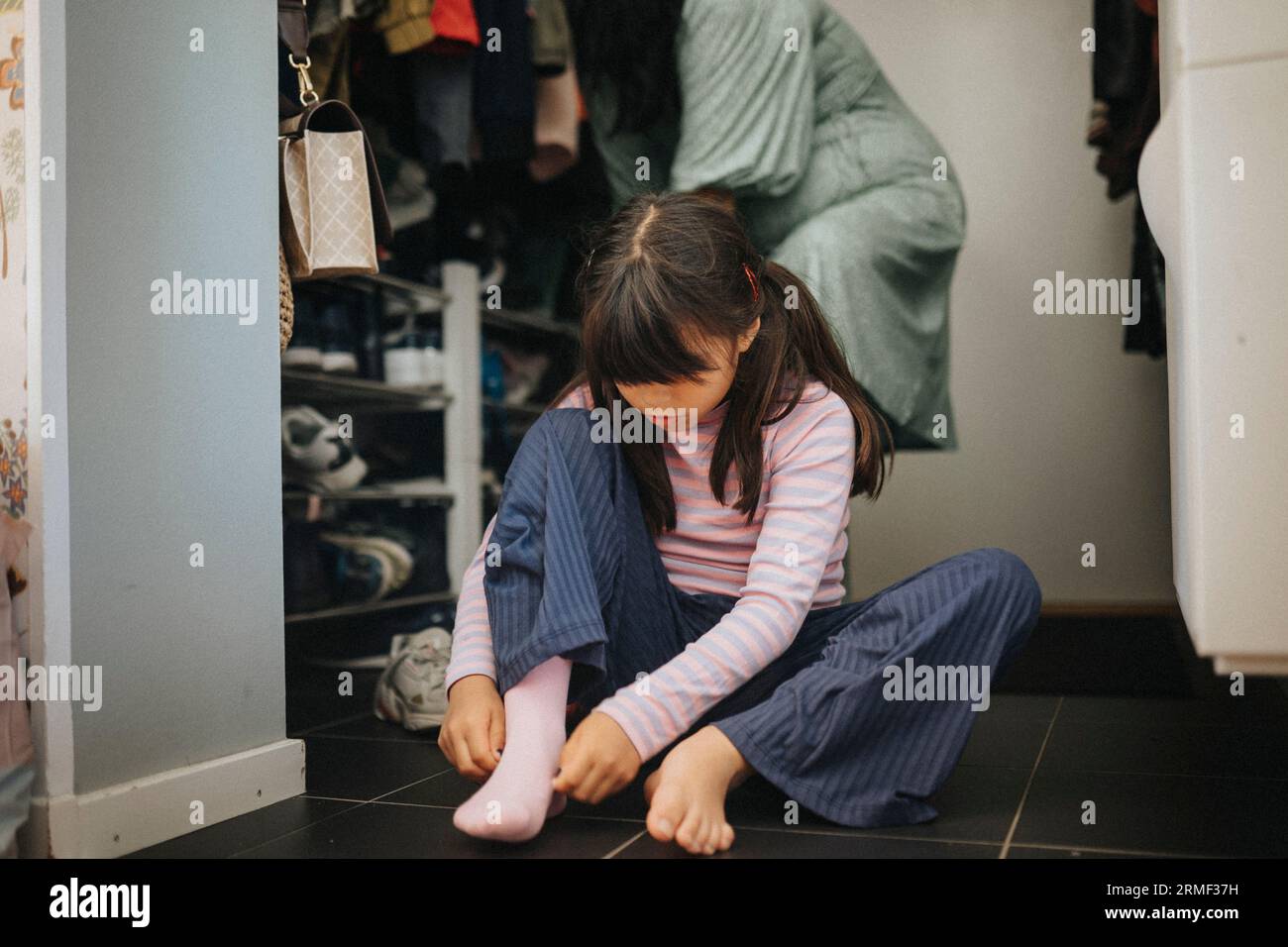 Madre e figlia si preparano ad uscire Foto Stock
