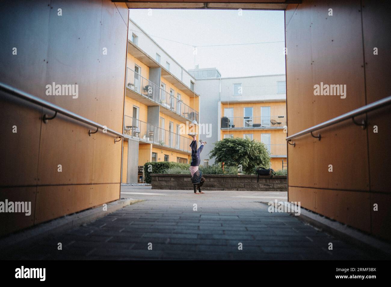 Ragazza che fa cartwheel nel cortile del quartiere Foto Stock