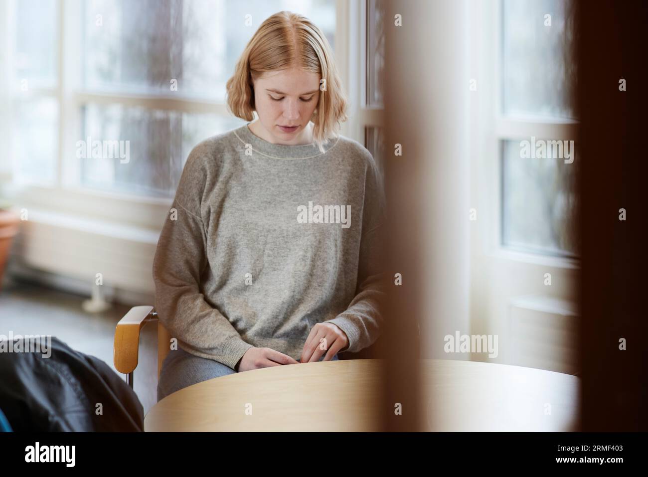 Ragazza adolescente in sala d'attesa che guarda altrove Foto Stock