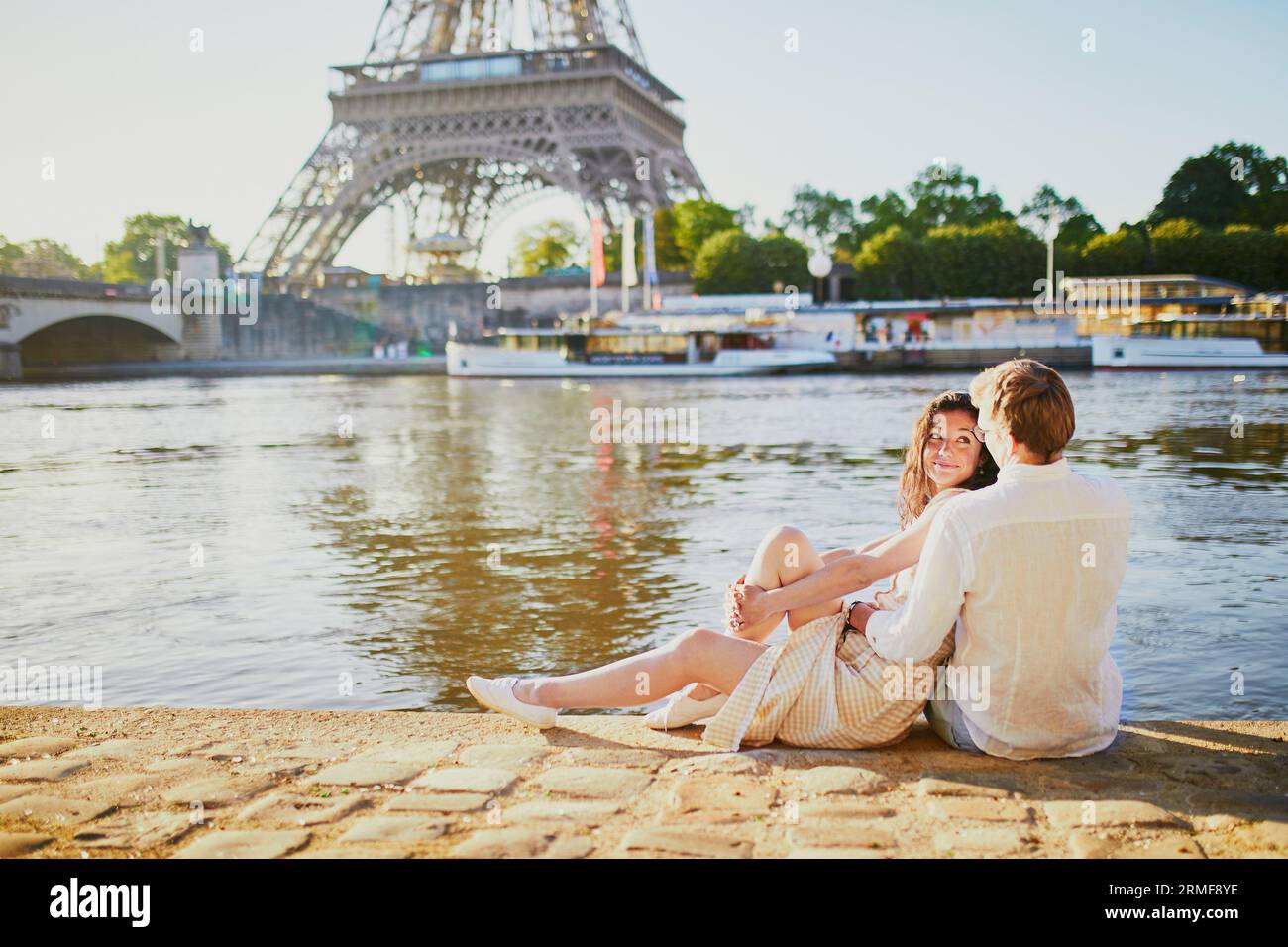 Felice coppia romantica a Parigi, vicino alla Torre Eiffel. Turisti che trascorrono le loro vacanze in Francia Foto Stock