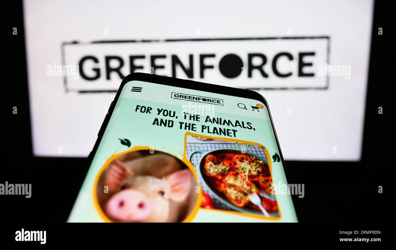 Smartphone con sito Web dell'azienda tedesca Greenforce Future Food AG sullo schermo davanti al logo aziendale. Mettere a fuoco in alto a sinistra sul display del telefono. Foto Stock