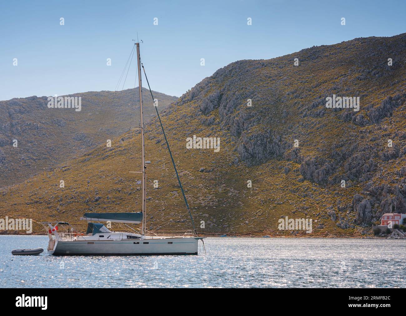 Isola di Symi, Grecia. Vacanze nelle isole della Grecia da Rodi nel Mar Egeo. Grande e bellissimo yacht nella baia vicino al villaggio di Pedi, vicino a Symi. Holiday trav Foto Stock