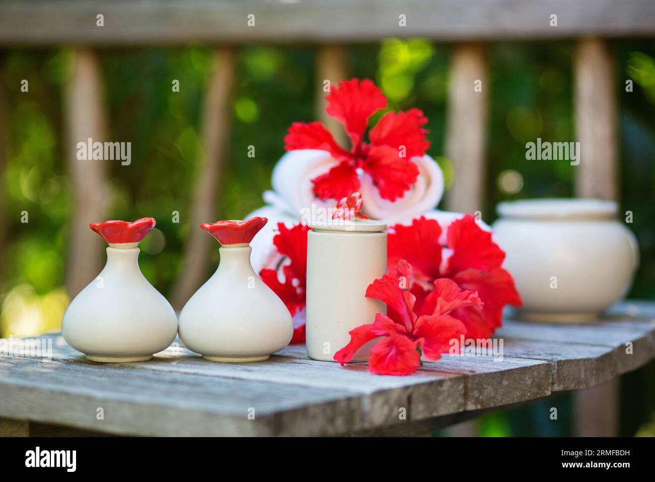 Ambiente benessere con asciugamani e bellissimi fiori rossi di ibisco Foto Stock