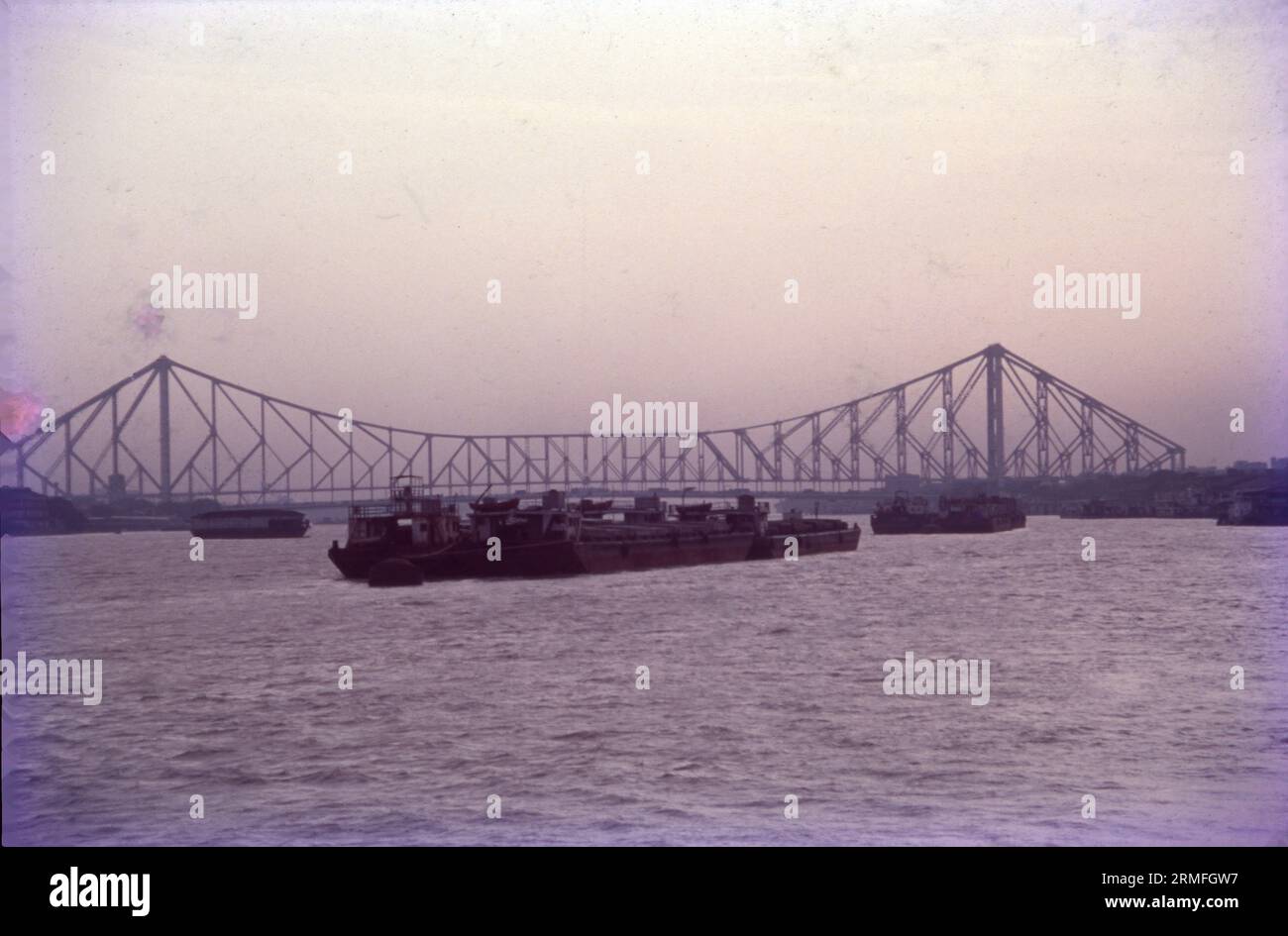 L'Howrah Bridge è un ponte a sbalzo bilanciato sul fiume Hoostly nel Bengala Occidentale, in India. Commissionato nel 1943, un simbolo di Kolkata, il ponte Howrah è un enorme ponte in acciaio sul fiume Hoostly. È considerato uno dei ponti a sbalzo più lunghi del mondo. Conosciuto anche come Rabindra Setu, collega Howrah e Kolkata. Trasporta 100.000 veicoli e innumerevoli pedoni al giorno. Foto Stock