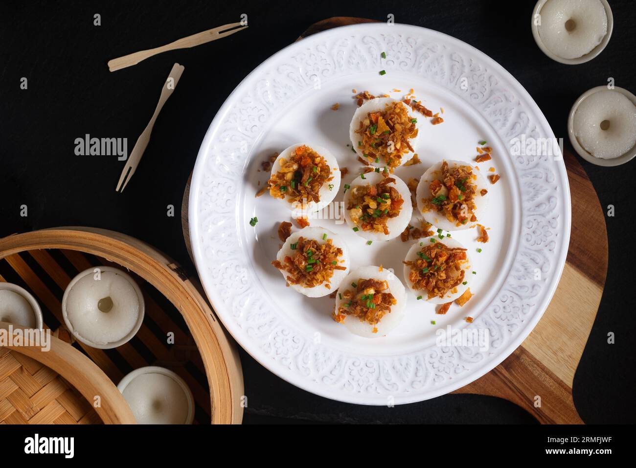 Il concetto di cucina asiatica si concentra sulla torta di riso salata Chwee Kueh Strem su sfondo nero con spazio per la copia Foto Stock