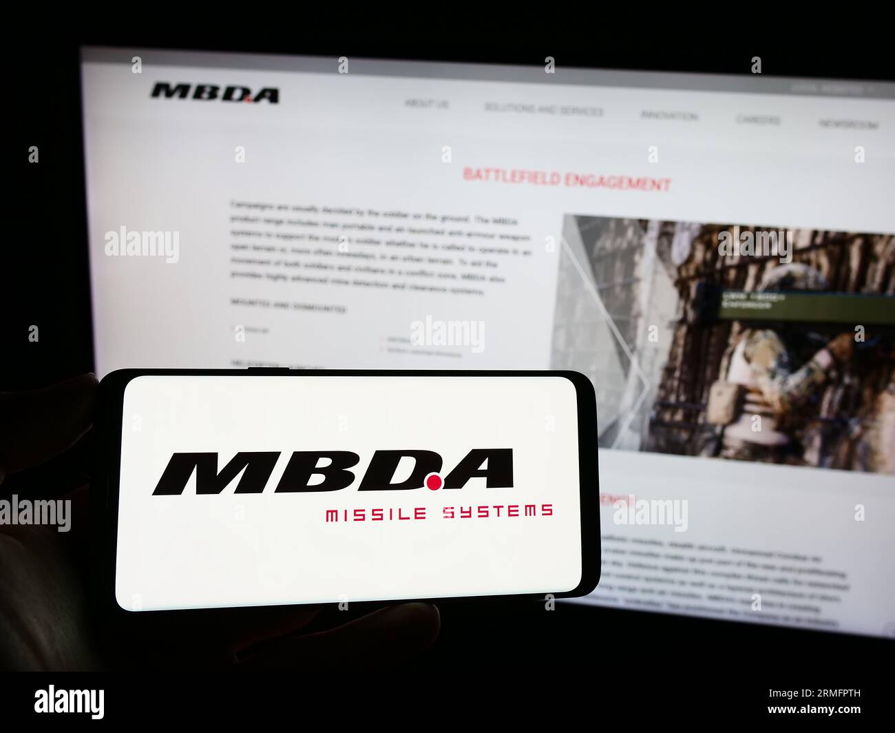 Persona che possiede un telefono cellulare con il logo dell'azienda francese di sistemi missilistici MBDA SAS sullo schermo davanti alla pagina Web aziendale. Concentrarsi sul display del telefono. Foto Stock