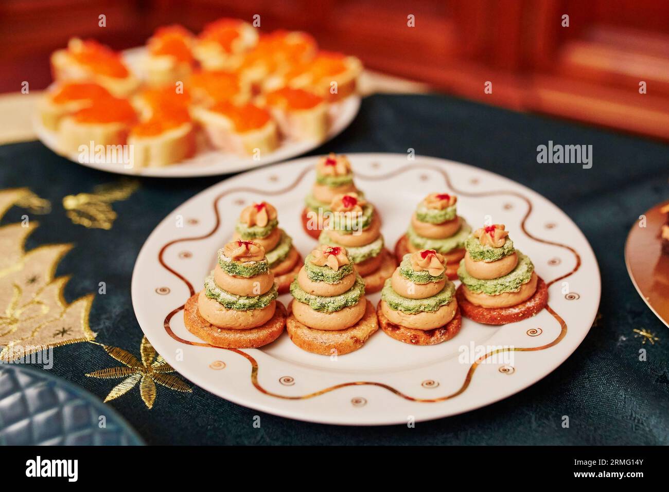 Set da tavolo per la cena di Natale con deliziosi antipasti - panini di fois gras sotto forma di piccoli alberi di Natale Foto Stock