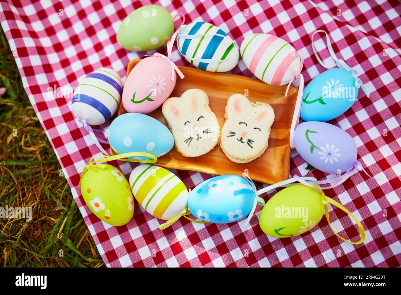 Picnic con deliziosi macaron dolci sotto forma di coniglietti pasquali e uova di Pasqua colorate. Festeggiamenti di Pasqua Foto Stock