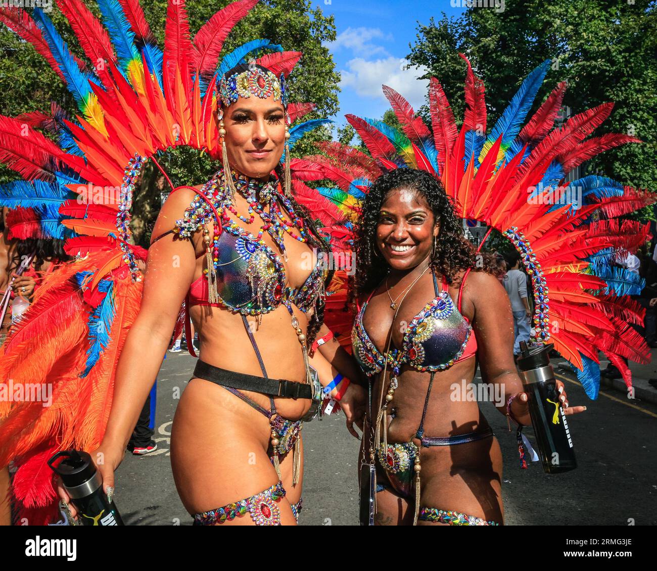 Londra, Regno Unito. 28 agosto 2023. Due partecipanti passeggiano per Notting Hill con i loro costumi dopo la parata. Dopo la sfilata, la folla si raduna per strada e intorno ai numerosi sistemi audio e bancarelle di cibo il lunedì di Carnevale. Si prevede che fino a due milioni di persone festeggeranno il carnevale durante il weekend festivo partecipando o guardando il carnevale. Crediti: Imageplotter/Alamy Live News Foto Stock