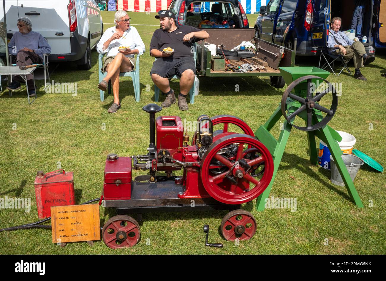 Un padre e un figlio appassionati di motori d'epoca stazionari siedono e mettono in mostra la loro macchina Amanco del 1911 in una festa di un villaggio a Wisborough Green, West Foto Stock