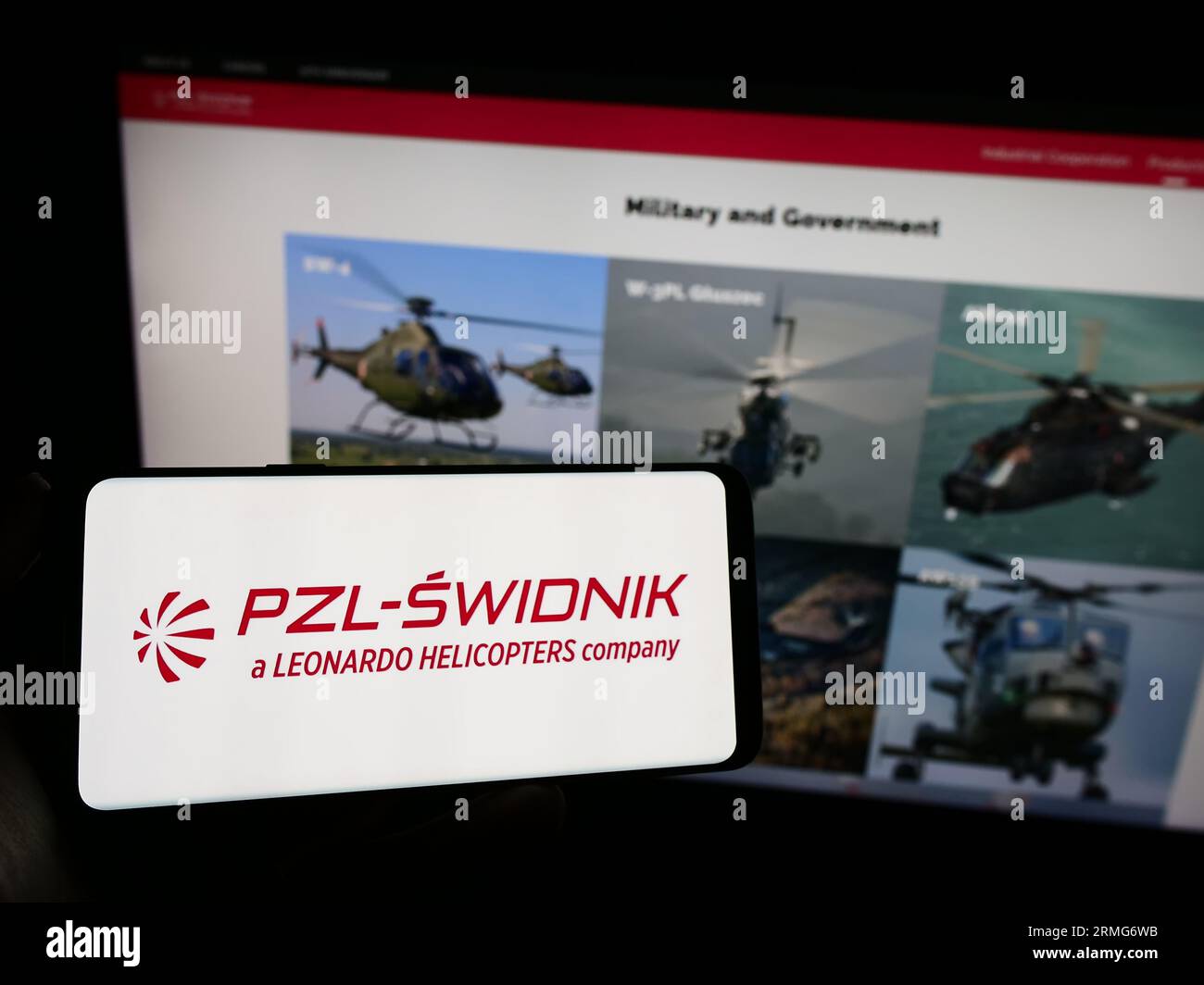 Persona che possiede un telefono cellulare con il logo della società polacca di difesa PZL-Swidnik SA sullo schermo davanti alla pagina Web aziendale. Concentrarsi sul display del telefono. Foto Stock