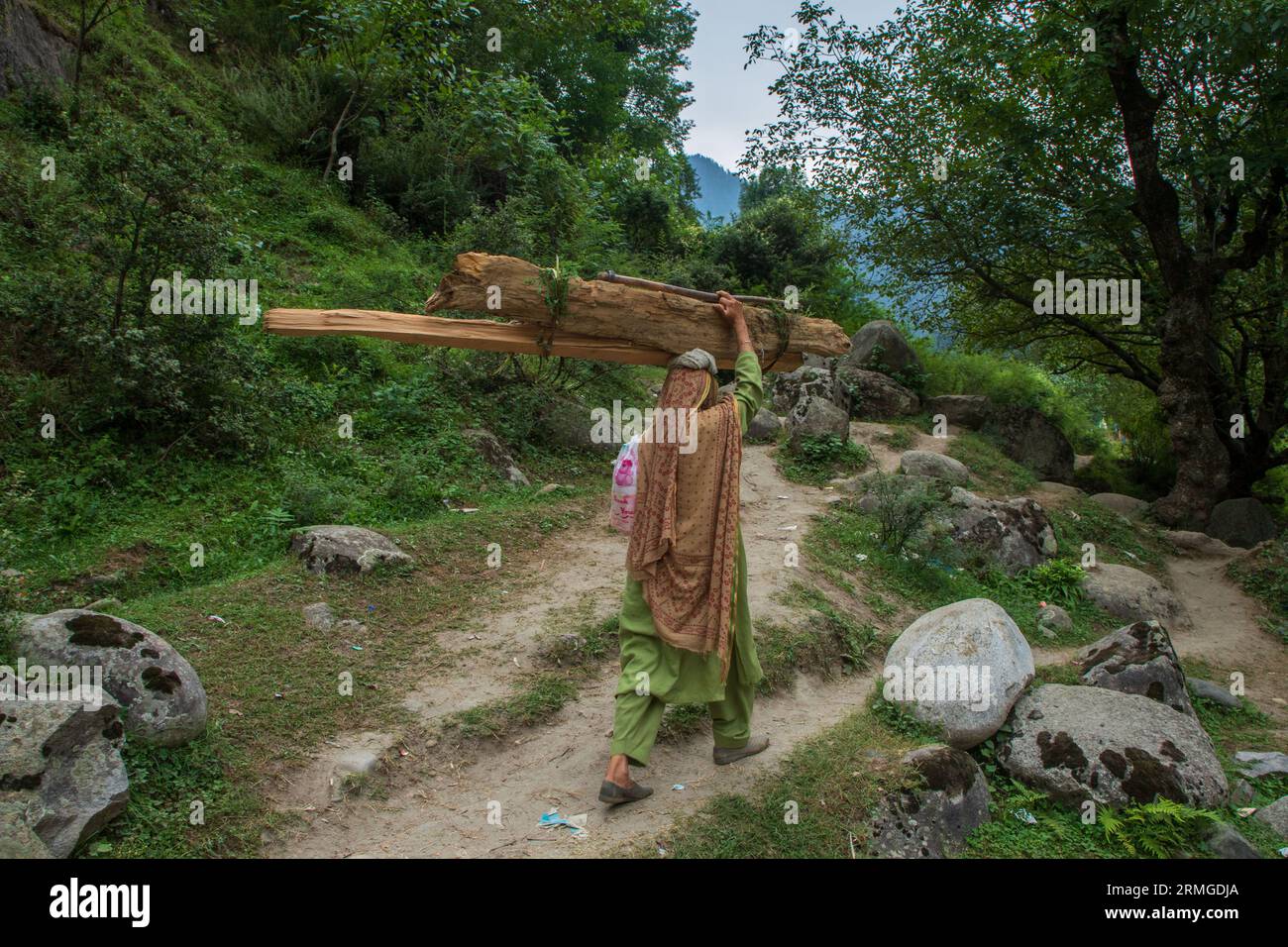 Keran, India. 25 agosto 2023. Una donna Kashmiri ha visto portare legna da ardere mentre tornava a casa nel villaggio di Keran, nel distretto di confine di Kupwara, circa 150 km a nord di Srinagar. Il villaggio di Keran si trova sulle rive del fiume Neelam o Kishan Ganga, sulla linea di controllo. Credito: SOPA Images Limited/Alamy Live News Foto Stock
