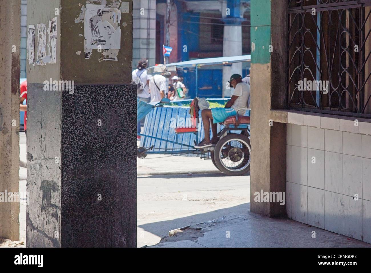 L'Avana, Cuba, 2023, Bicitaxi incorniciato in colonna con giornali pubblicitari bloccati. Foto Stock