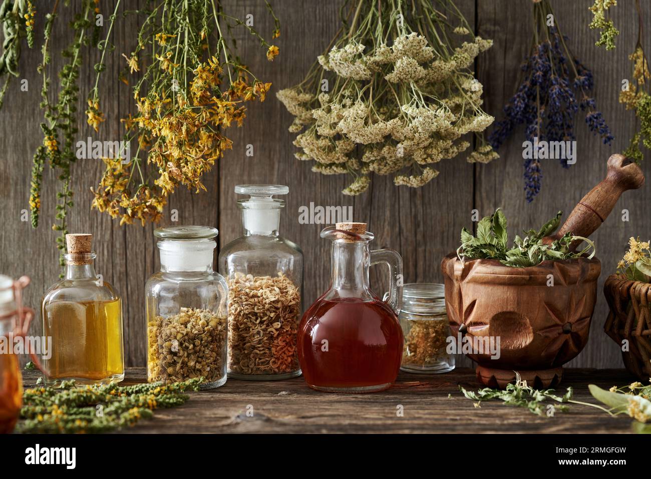 Tinture e oli, con essiccazione di St. Erba di Giovanni, yarrow, agromia, lavanda e altre erbe appese sopra di loro Foto Stock