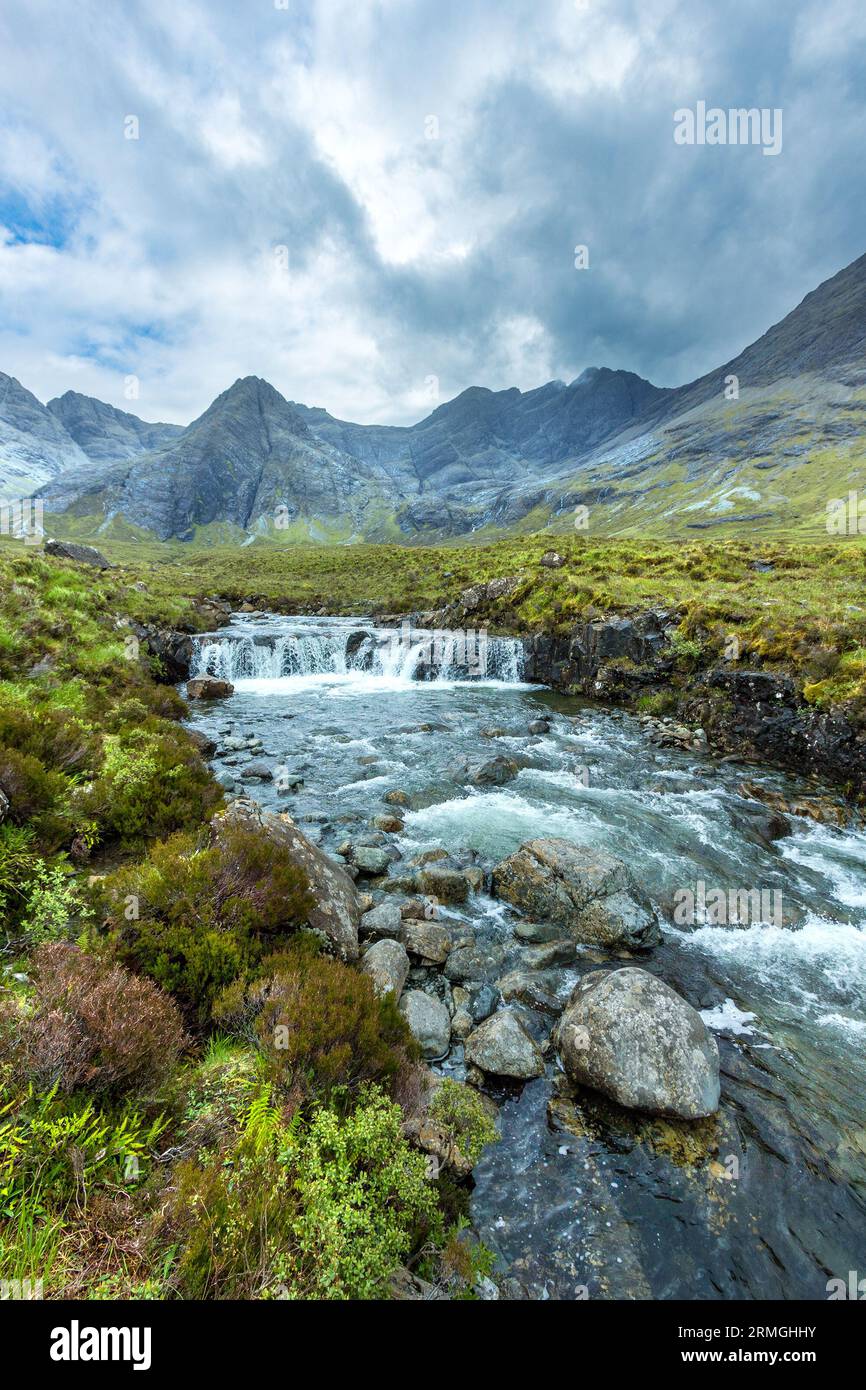 Cascata con cielo drammatico e nero montagne Cuillin oltre, coire na Creiche, Glen fragile, Isola di Skye, Scotland, Regno Unito Foto Stock