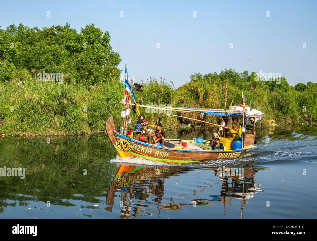 Una barca da pesca colorata naviga nel canale vicino alla baia di Giacarta. Giava, Indonesia. Foto Stock