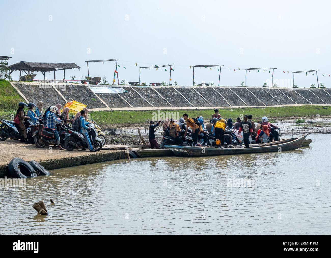 Persone e motociclette sono bloccate sui piccoli traghetti. Sumatra, Indonesia. Foto Stock