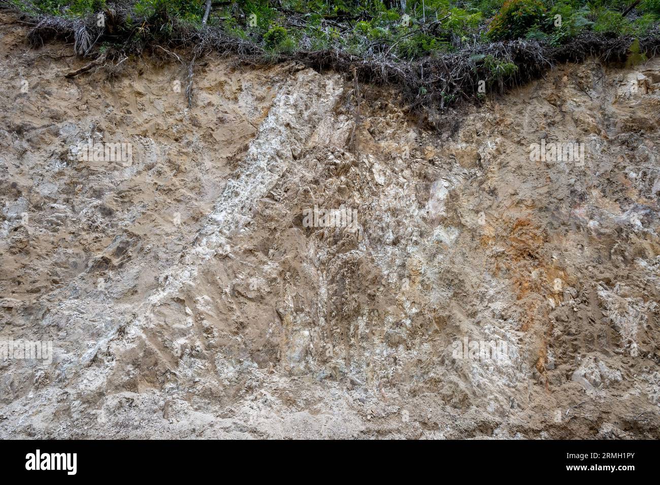 Strati di detriti vulcanici e depositi di ceneri su una strada tagliata. Sumatra, Indonesia. Foto Stock