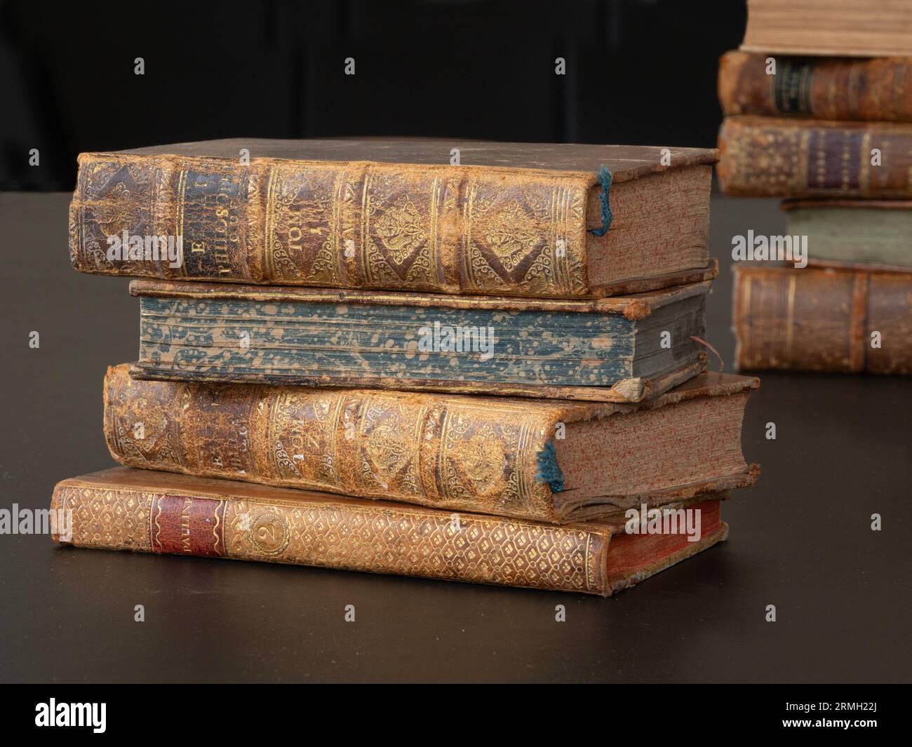 Mucchio di vecchi libri d'epoca sdraiati su un tavolo nero. Foto Stock