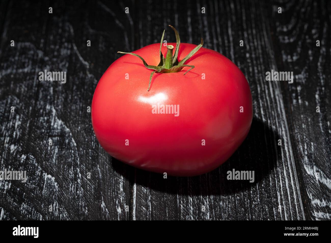 pomodoro rosa su fondo di legno Foto Stock