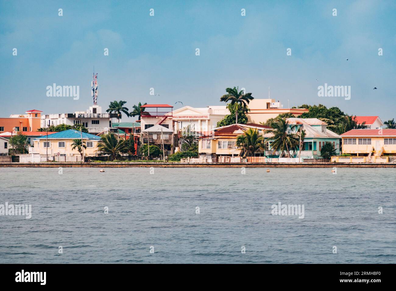 Una varieta' di case colorate ai bordi delle acque di Belize City, Belize Foto Stock