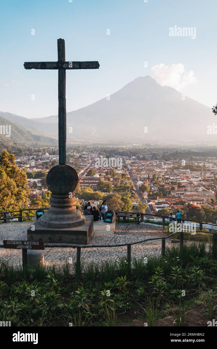 Una vista del vulcano Agua dalla Collina della Croce, un punto panoramico con una croce di legno che si affaccia sulla storica città di Antigua Guatemala Foto Stock