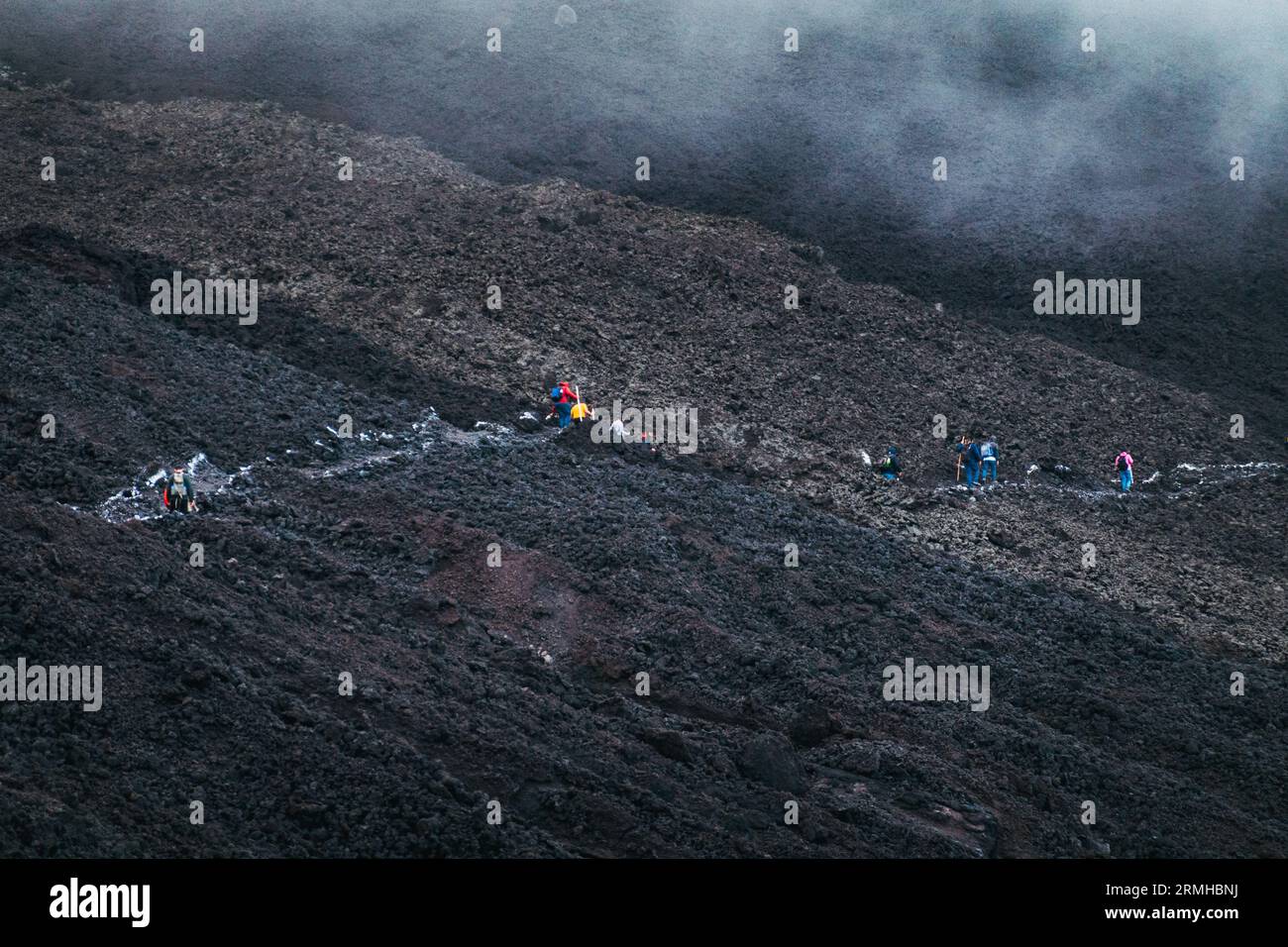 Gli escursionisti camminano attraverso le calde e fumanti pendici vulcaniche del vulcano Pacaya, Guatemala Foto Stock