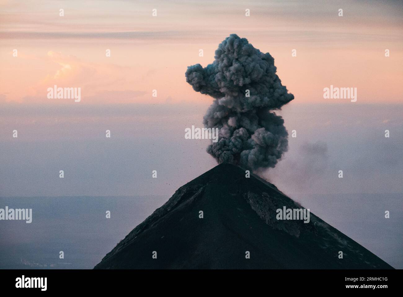 Un pennacchio di fumo e cenere erutta dal cratere del vulcano Fuego, visto dall'adiacente vulcano Acatenango, Guatemala, all'alba Foto Stock