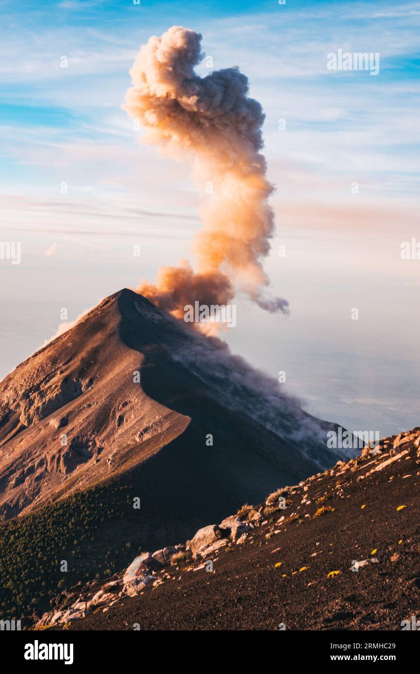 Un pennacchio di fumo e cenere erutta dal cratere del vulcano Fuego, visto dall'adiacente vulcano Acatenango, Guatemala, all'alba Foto Stock