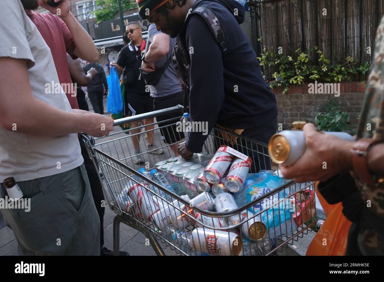 L'uomo vende lattine di birra in un tram per lo shopping ai festeggiamenti del Carnevale di Notting Hill per la celebrazione della cultura caraibica. 28/08/2023 Foto Stock