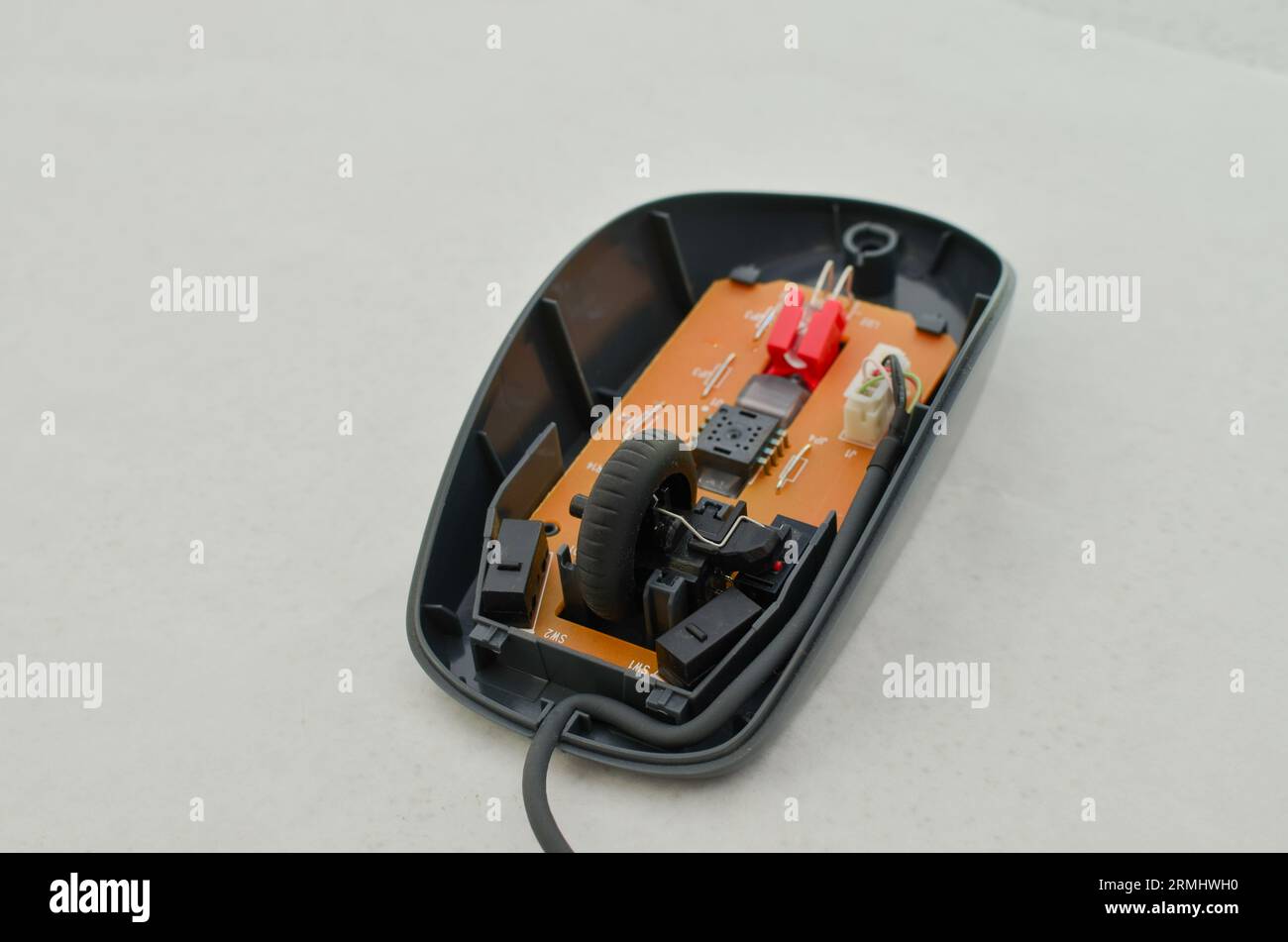 Mouse per computer aperto con circuito elettronico esposto per la manutenzione, simbolo della tecnologia e dell'informatica moderna. Perfetto per concetti tecnologici, cifra Foto Stock