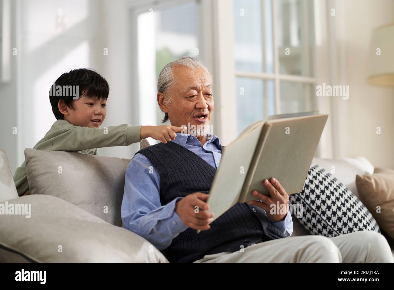 nonno asiatico anziano che si diverte con il nipote a casa Foto Stock