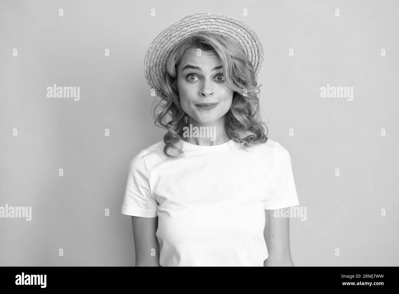 Giovane donna rossa in cappello di paglia, espressione sorpresa, isolato su sfondo giallo. Ritratto da studio estivo. Foto Stock