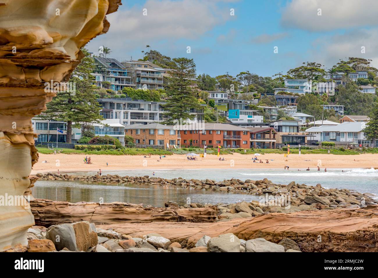Persone che nuotano sulla spiaggia vicino alla piscina dell'oceano, alla popolare estremità meridionale di Avoca Beach sulla costa centrale del nuovo Galles del Sud, Australia Foto Stock