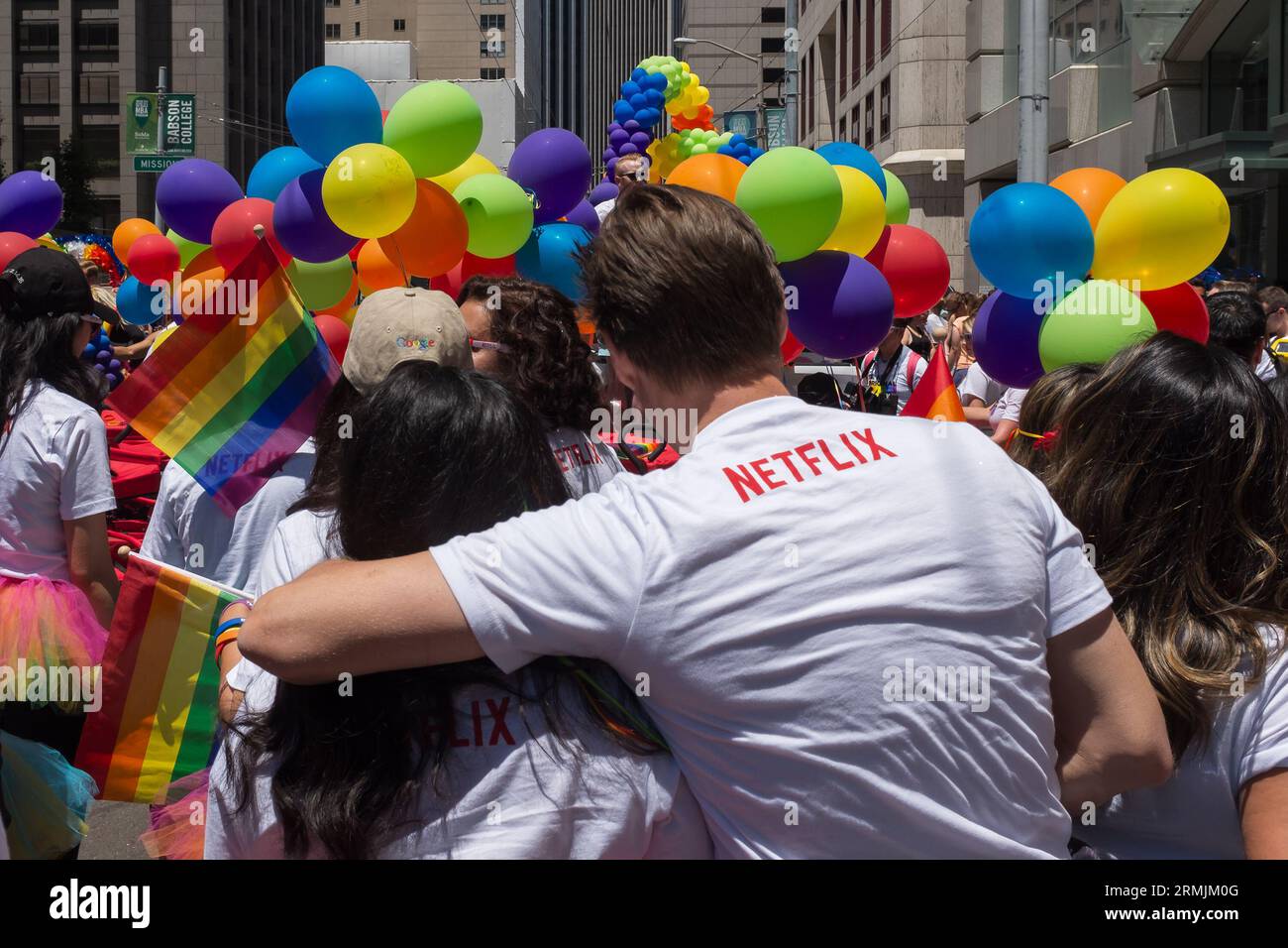San Francisco, California, 2016. Persone che indossano lo swag della Silicon Valley, come i cappelli Google e le magliette Netflix, che celebrano la sfilata del Pride Foto Stock
