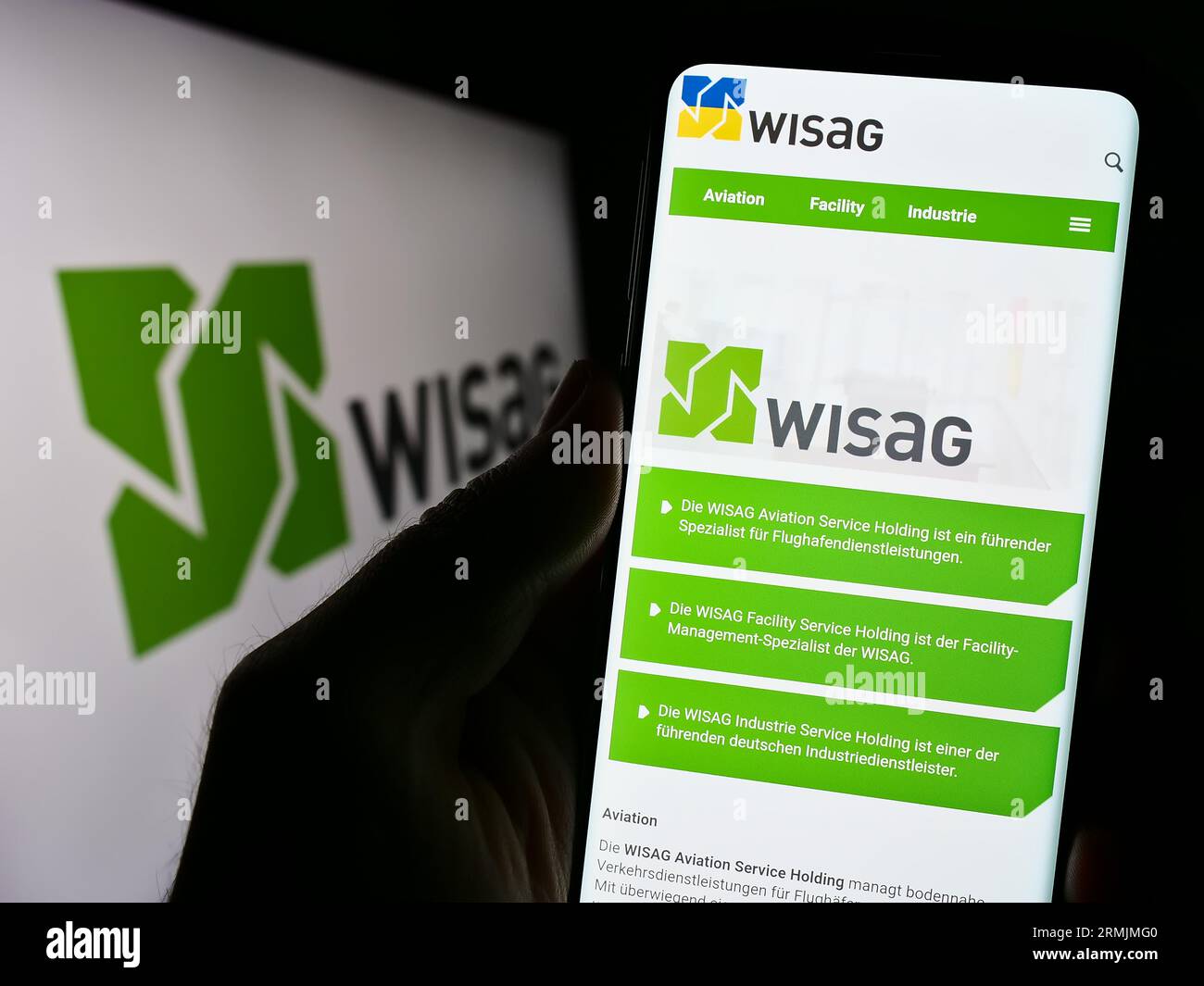 Persona che possiede il cellulare con la pagina Web dell'azienda tedesca WISAG Dienstleistungsholding se sullo schermo con logo. Concentrarsi sul centro del display del telefono. Foto Stock