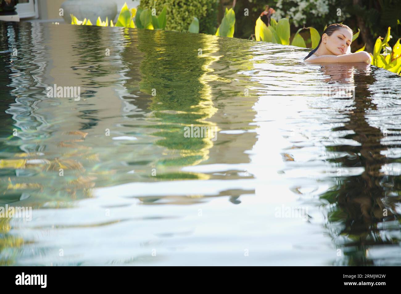 Ritratto di giovane donna in un'esotica piscina appoggiata Foto Stock
